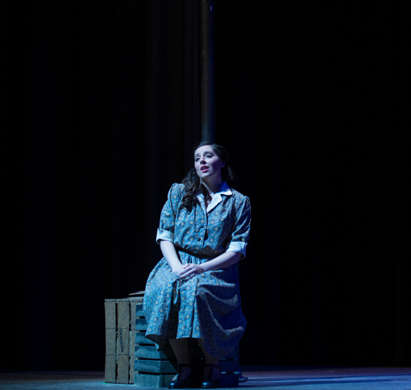Loyola student Haley Whitney sings under a street lamp in the opera production of Street Scene. 