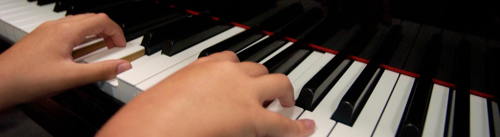 The hands of a child playing the paino