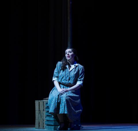 Loyola student Haley Whitney sings under a street lamp in the opera production of Street Scene. 