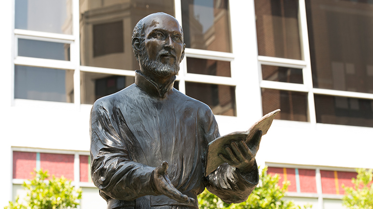 Close up image of St. Ignatius statue with hand extended