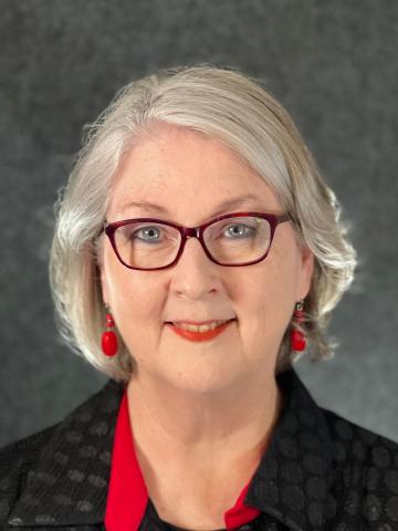Woman, silver hair, glasses, black and red attire